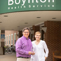 Dave and Holly with the award in front of Boynton Health