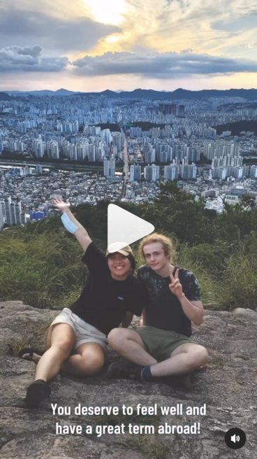 Screenshot of video featuring two students overlooking a cityscape, with caption reading "You deserve to feel well and have a great term abroad!"