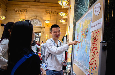 A student points to a location on a world map in Walter Library