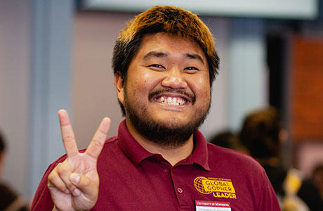 international student displaying a peace sign with his hand