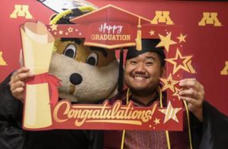 Yuth in a graduation cap with Goldy Gopher