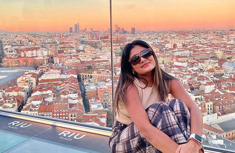 Student on a Learning Abroad Center program poses with the skyline of Madrid