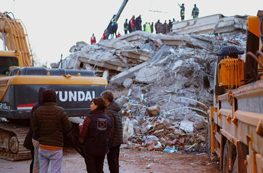 aid workers in front of earthquake destruction