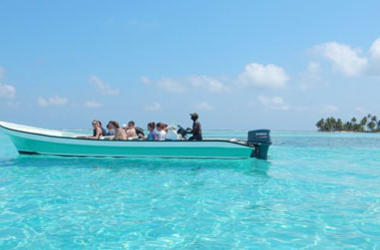 study abroad students on a boat in a blue ocean