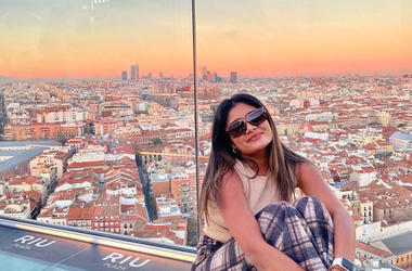 Zeel Patel sitting on a balcony at sunset