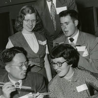 1950: A student coaches others on how to use chopsticks