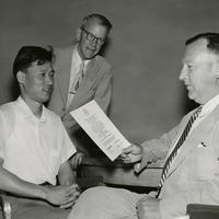 1956: Athelstan Frederick Spilhaus, a geophysicist and oceanographer, presents a certificate to a Korean student