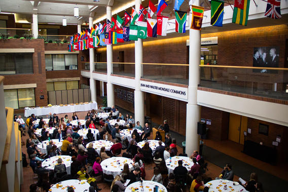 overhead view of conference attendees sitting at tables and listening to a speaker