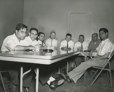 Male-appearing people, including Josef Mestenhauser and Forrest Moore, sit around a folding table