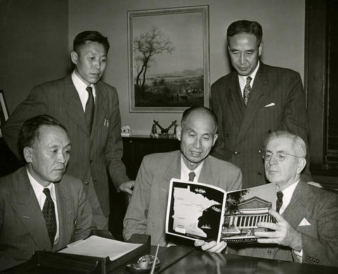 Seoul National University leaders with Harold Macy looking at UMN brochure